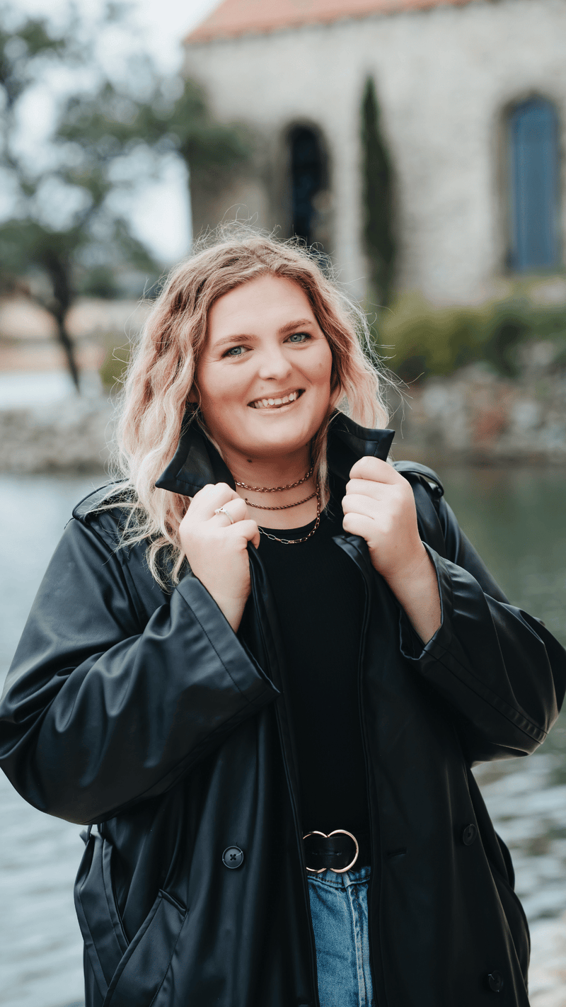 Woman wearing a black jacket with a scenic background